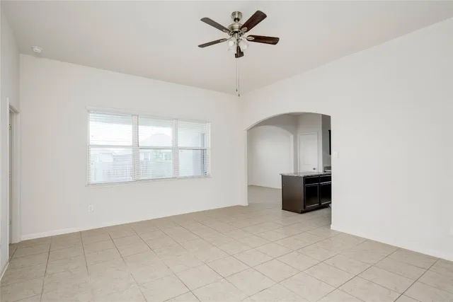 a view of empty room with a ceiling fan and window