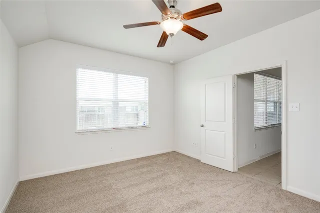 an empty room with fan and windows