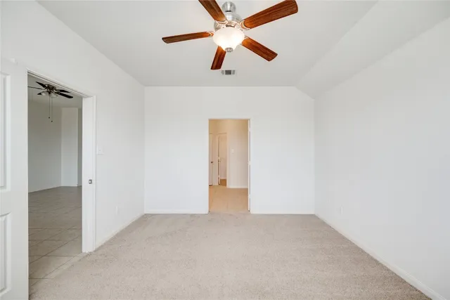 an empty room with closet and fan