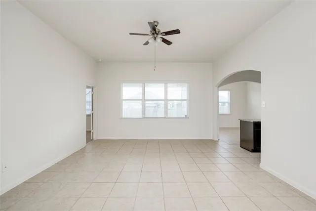 an empty room with windows and ceiling fan