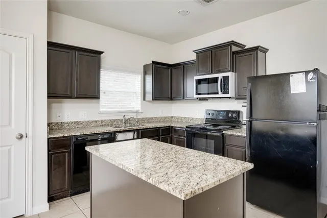 a kitchen with a stove a refrigerator and a sink