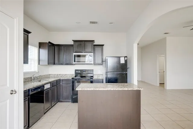 a kitchen with stainless steel appliances a stove sink and refrigerator