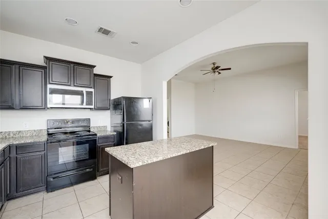 a kitchen with stainless steel appliances granite countertop a refrigerator and a stove top oven