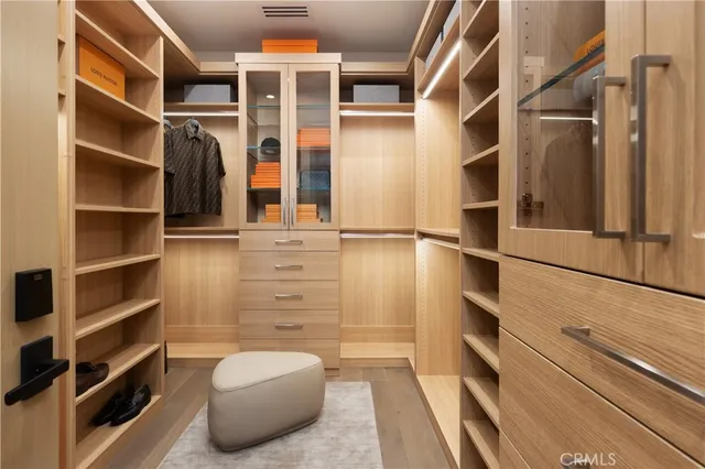 a view of walk in closet with clothes and shoes