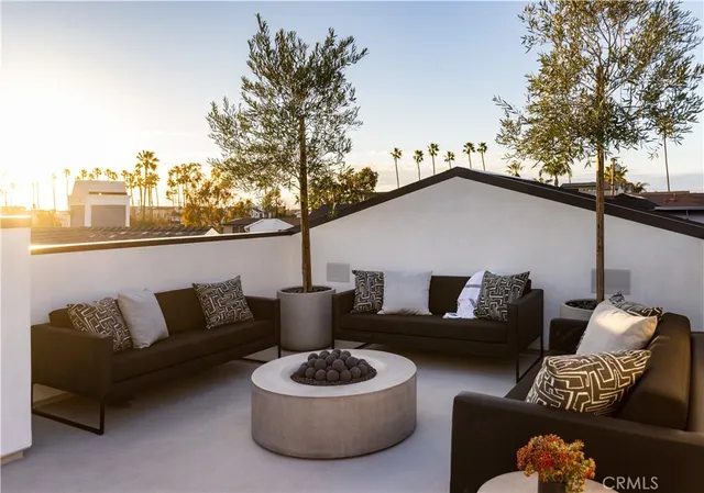 a roof deck with couches and potted plants