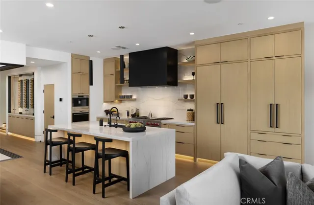 a kitchen with stainless steel appliances kitchen island granite countertop a refrigerator and a stove top oven