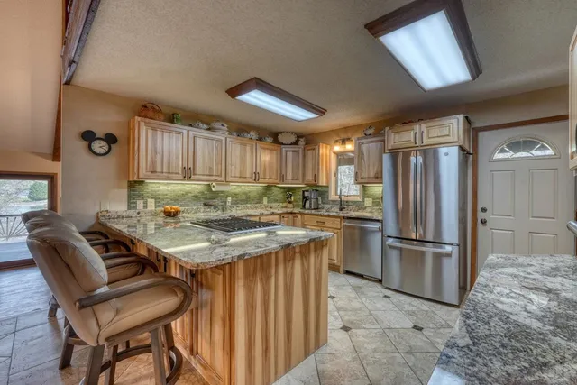 a kitchen with stainless steel appliances granite countertop a refrigerator and a sink