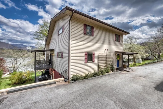 a view of a house with a yard and wooden fence