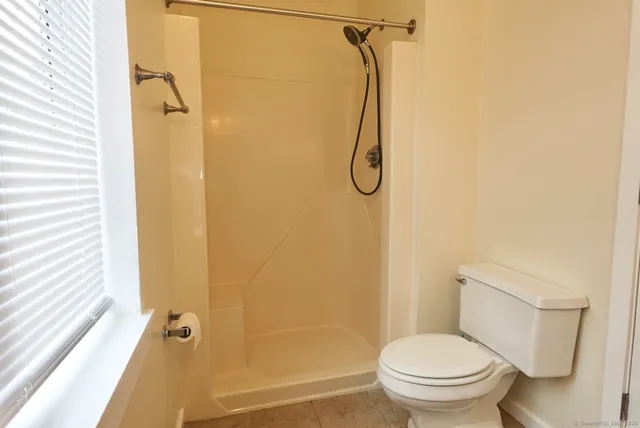 a bathroom with a shower a toilet and a shower