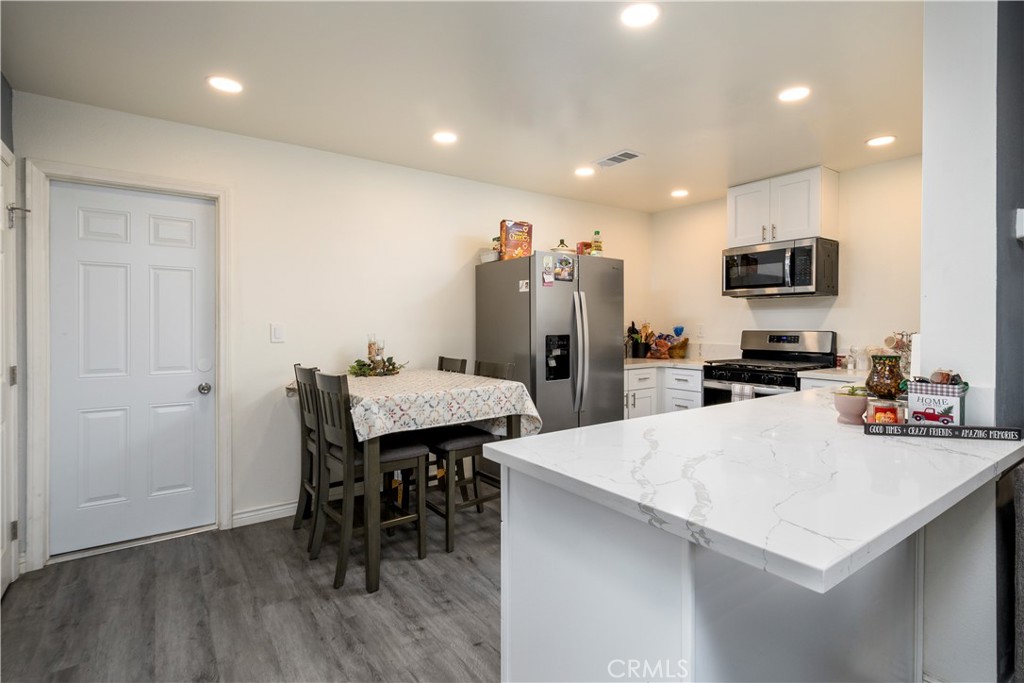 1709 Paramount Boulevard Montebello, CA 90640 - Photo 3 of 19 a kitchen with stainless steel appliances a refrigerator and a dining table