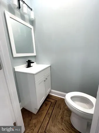 a bathroom with a toilet a sink and mirror