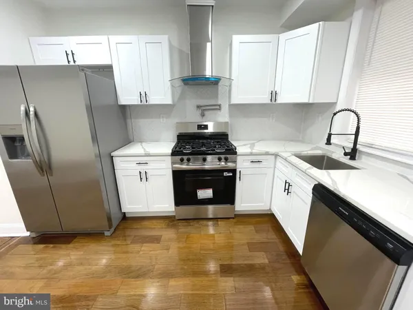 a kitchen with stainless steel appliances granite countertop a stove a sink and a refrigerator
