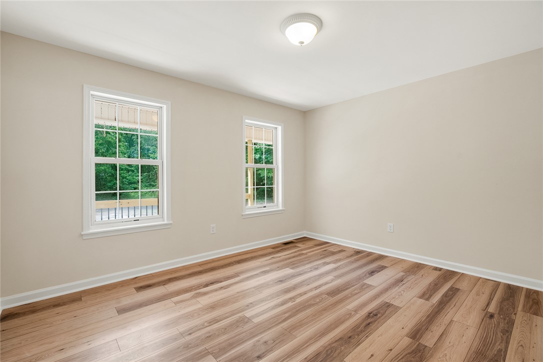 131 Lockaby Road Pelzer, SC 29669 - Photo 33 of 50 This bright bedroom features beautiful wood flooring, offering a fresh canvas for your personal style.