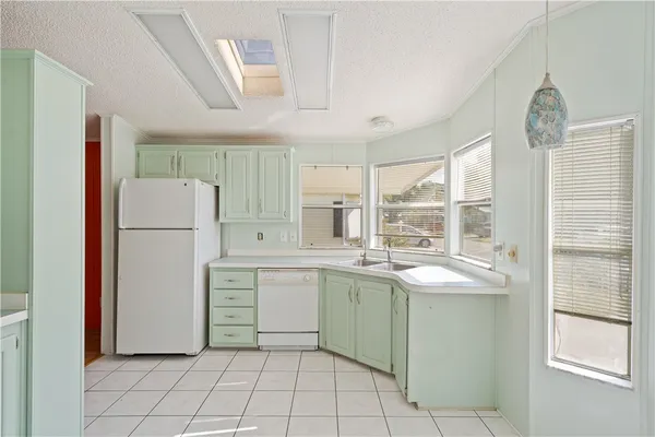a kitchen with a sink a refrigerator and cabinets