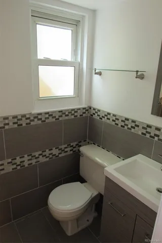 a bathroom with a toilet a sink and a window