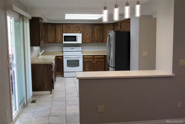 a kitchen with stainless steel appliances granite countertop a refrigerator and a stove top oven