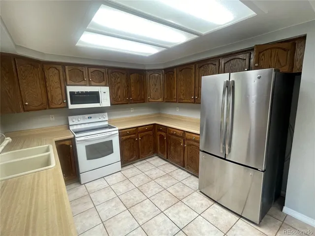 a kitchen with stainless steel appliances a refrigerator sink and microwave