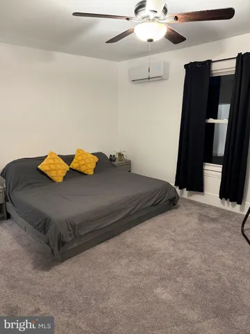 a bedroom with a bed and a ceiling fan