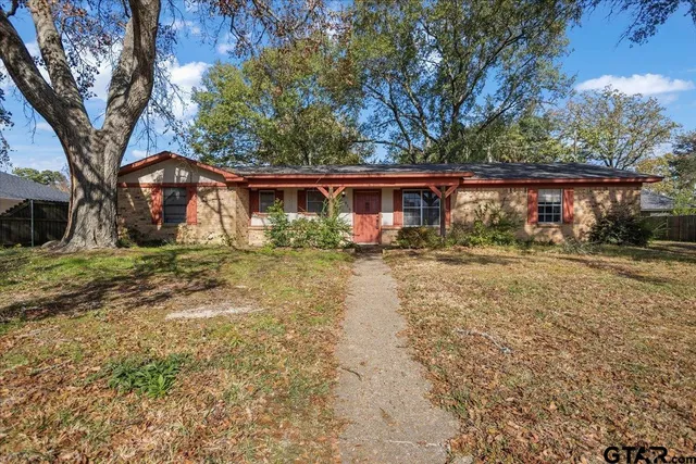 a front view of house with yard and trees around