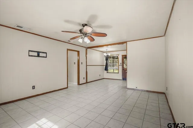 a view of a livingroom with a chandelier fan and windows
