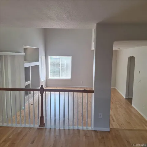 a view of a hallway with wooden floor and stairs