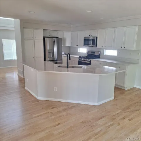 a large kitchen with stainless steel appliances granite countertop a large counter top and a stove top oven