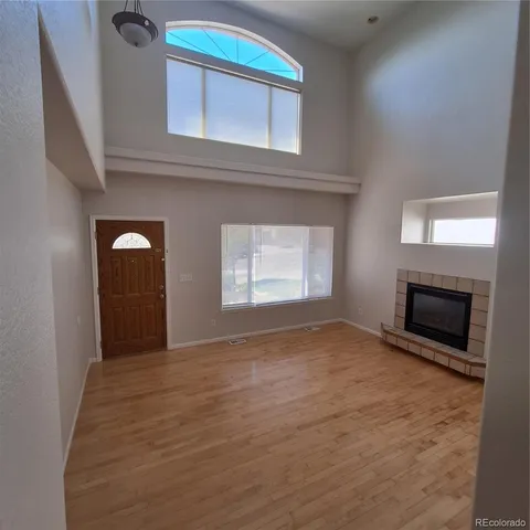 a view of an empty room with a fireplace and a window