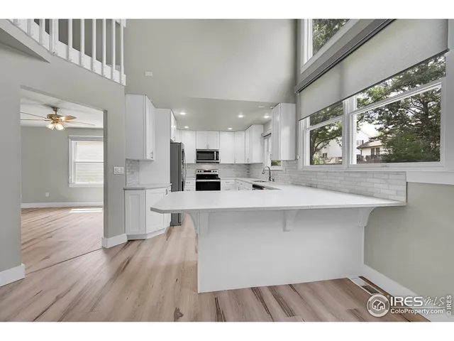 a kitchen view with wooden floor a sink and a refrigerator