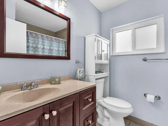 a bathroom with a sink a toilet and a mirror