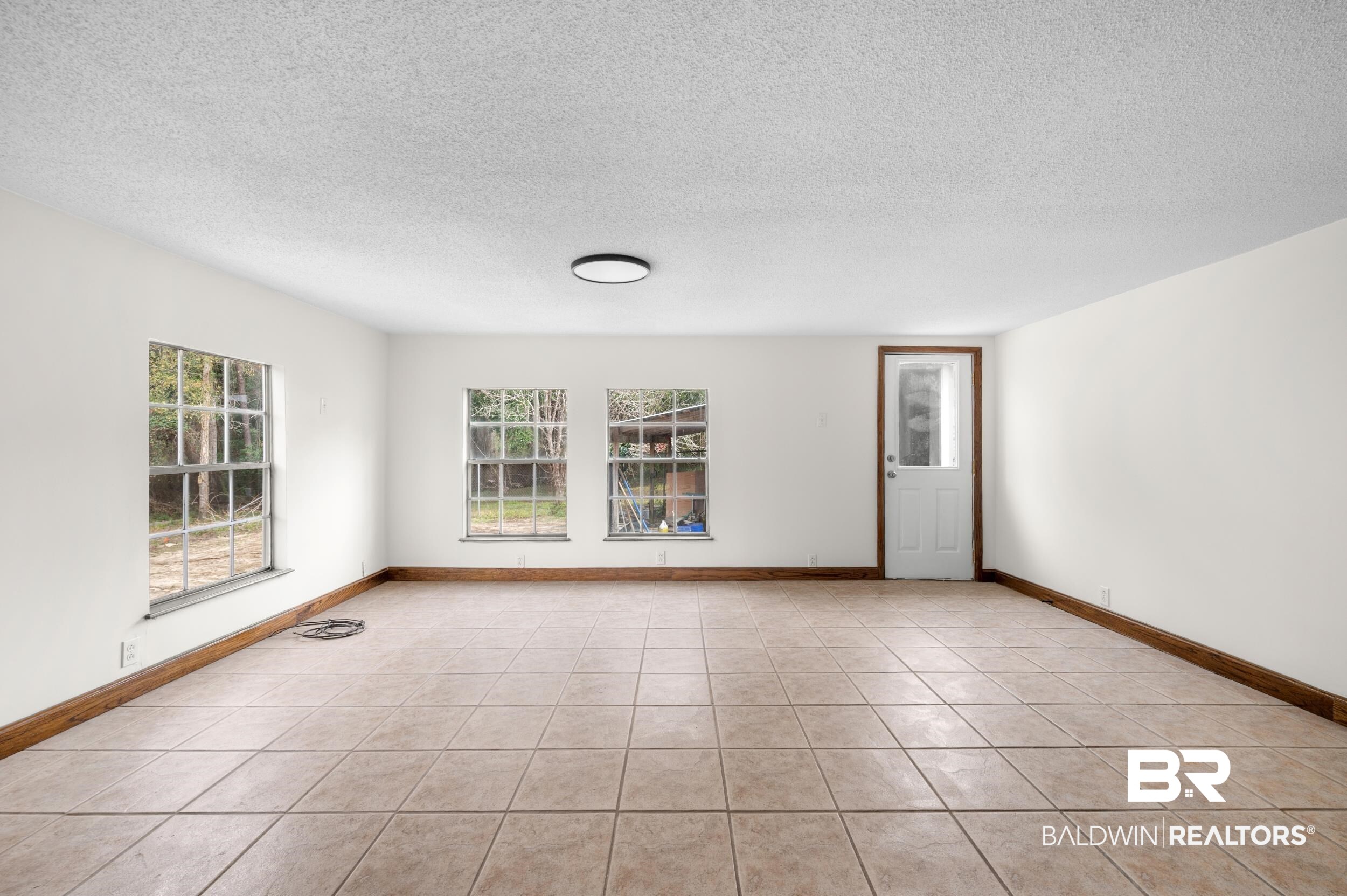 35780 Spring Road North Stapleton, AL 36578 - Photo 26 of 41 Empty room with healthy amount of natural light, a textured ceiling, and light tile patterned floors