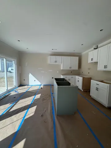 a kitchen with stainless steel appliances granite countertop a sink and cabinets with wooden floor