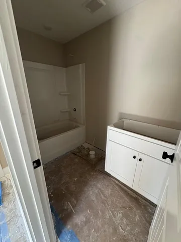 an empty room with windows and ceiling fan