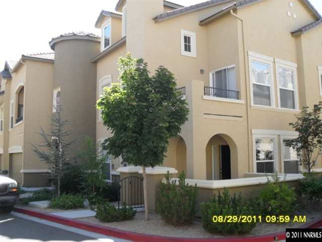 9050 Double R Boulevard, Unit 1812 Reno, NV 89521 - Photo 1 of 8 a view of a white house with a yard and plants