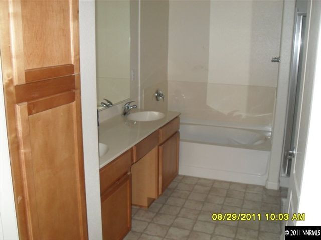 9050 Double R Boulevard, Unit 1812 Reno, NV 89521 - Photo 7 of 8 a bathroom with a granite countertop sink and a shower