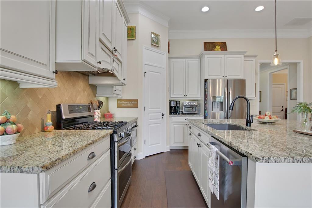 407 Windy Ridge Way Canton, GA 30114 - Photo 11 of 57 a kitchen with granite countertop a sink a stove and cabinets