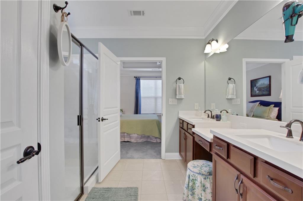 407 Windy Ridge Way Canton, GA 30114 - Photo 25 of 57 a en suite bathroom with a double vanity sink a large mirror and a bathtub