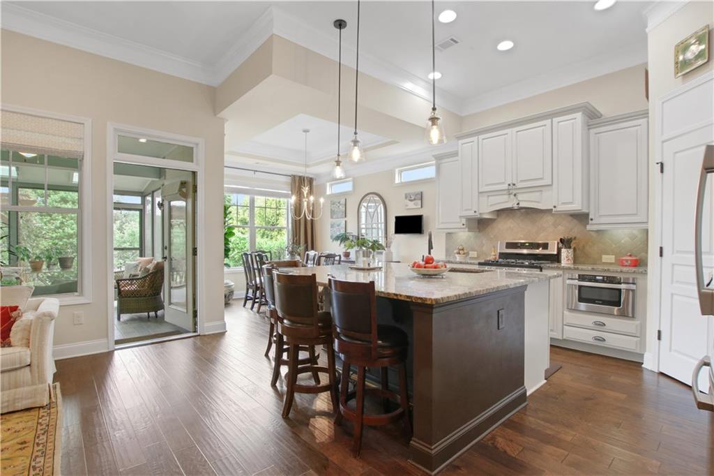 407 Windy Ridge Way Canton, GA 30114 - Photo 9 of 57 a kitchen with a sink stove and white cabinets with wooden floor