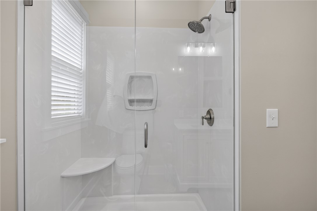 405 Pawnee Drive Walhalla, SC 29691 - Photo 13 of 36 A well-appointed shower stall features a built-in bench and a window providing natural illumination.