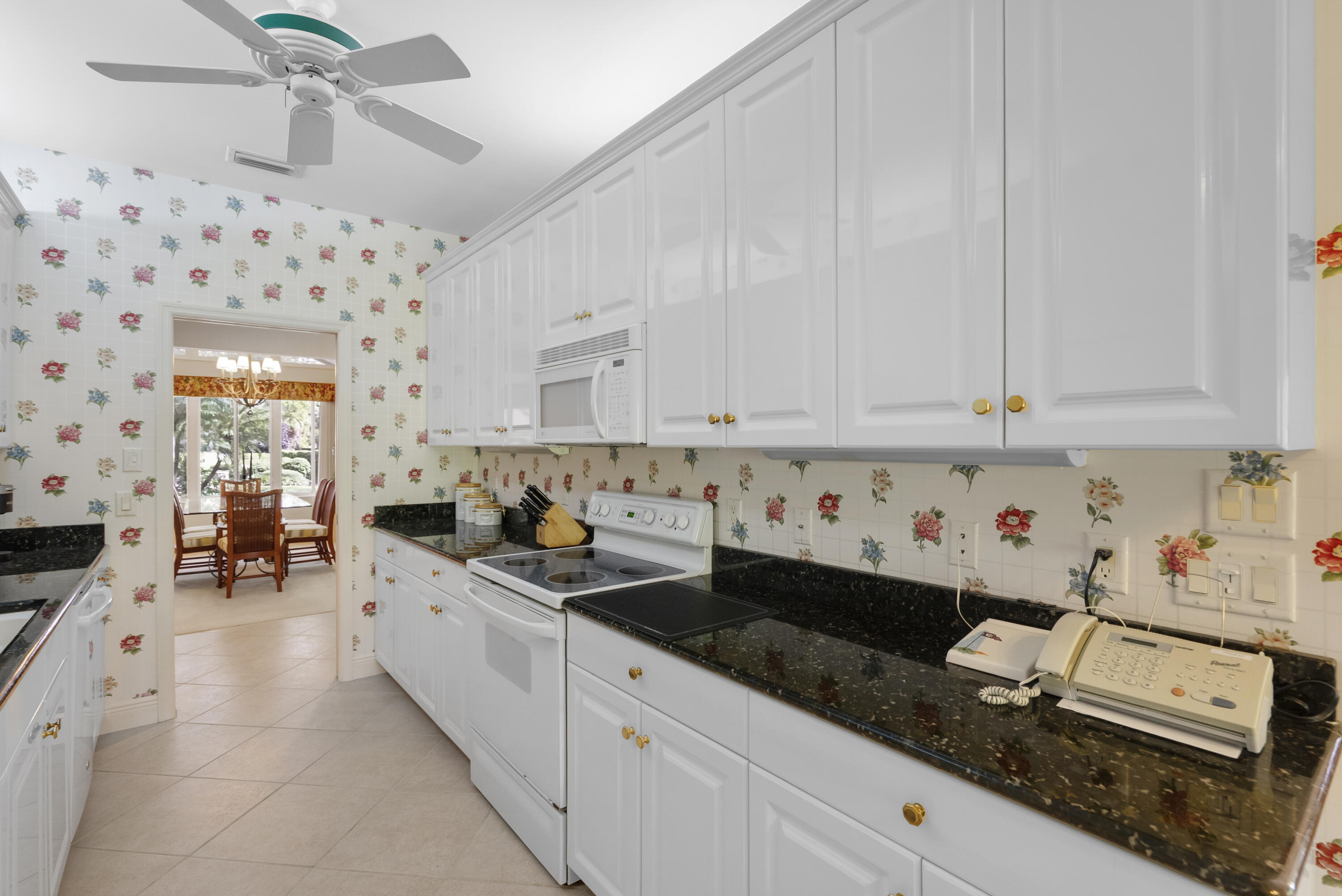 5011 Southeast Burning Tree Circle Stuart, FL 34997 - Photo 14 of 59 a kitchen with granite countertop a sink dishwasher stove and white cabinets