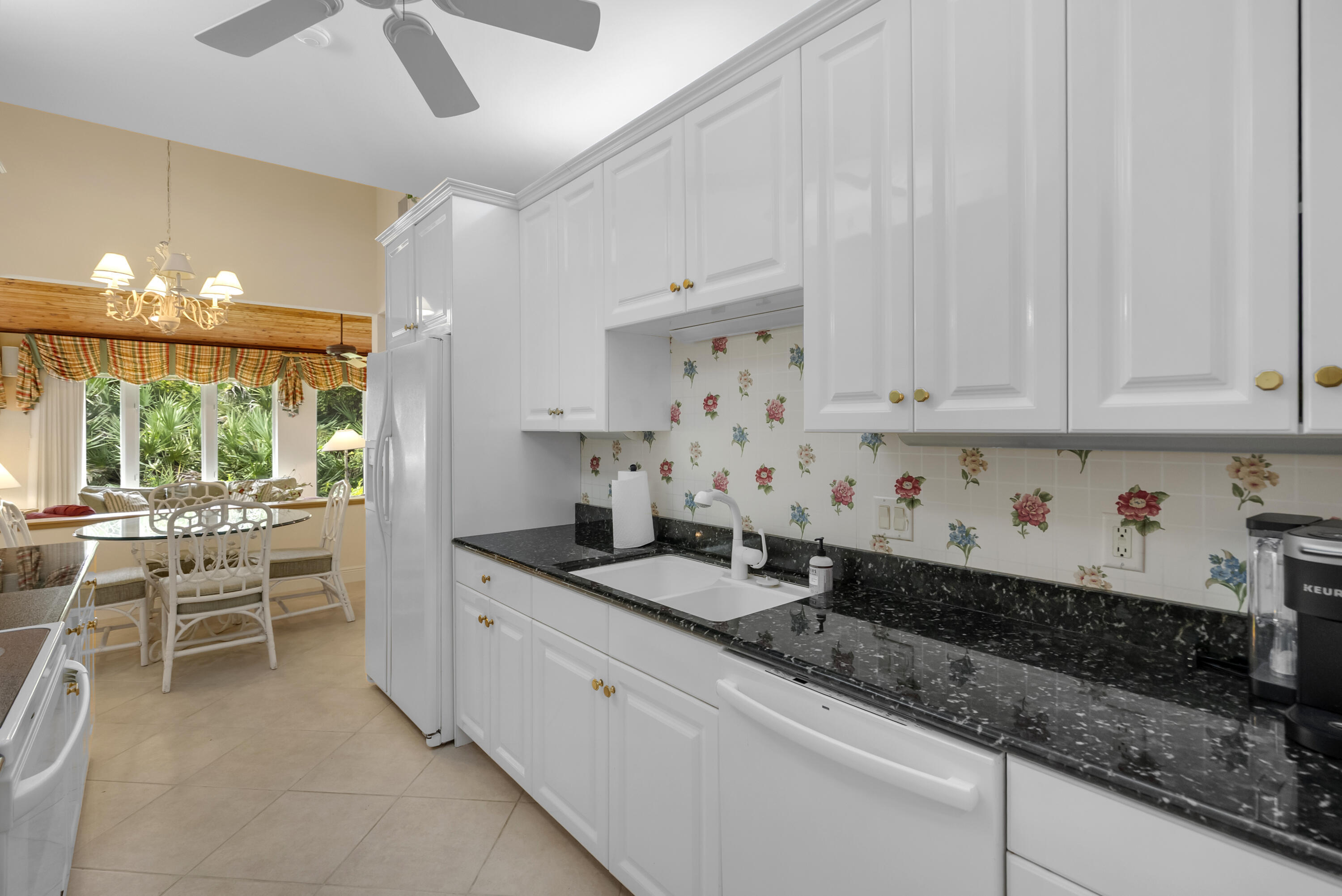 5011 Southeast Burning Tree Circle Stuart, FL 34997 - Photo 15 of 59 a kitchen with granite countertop a sink a stove and cabinets