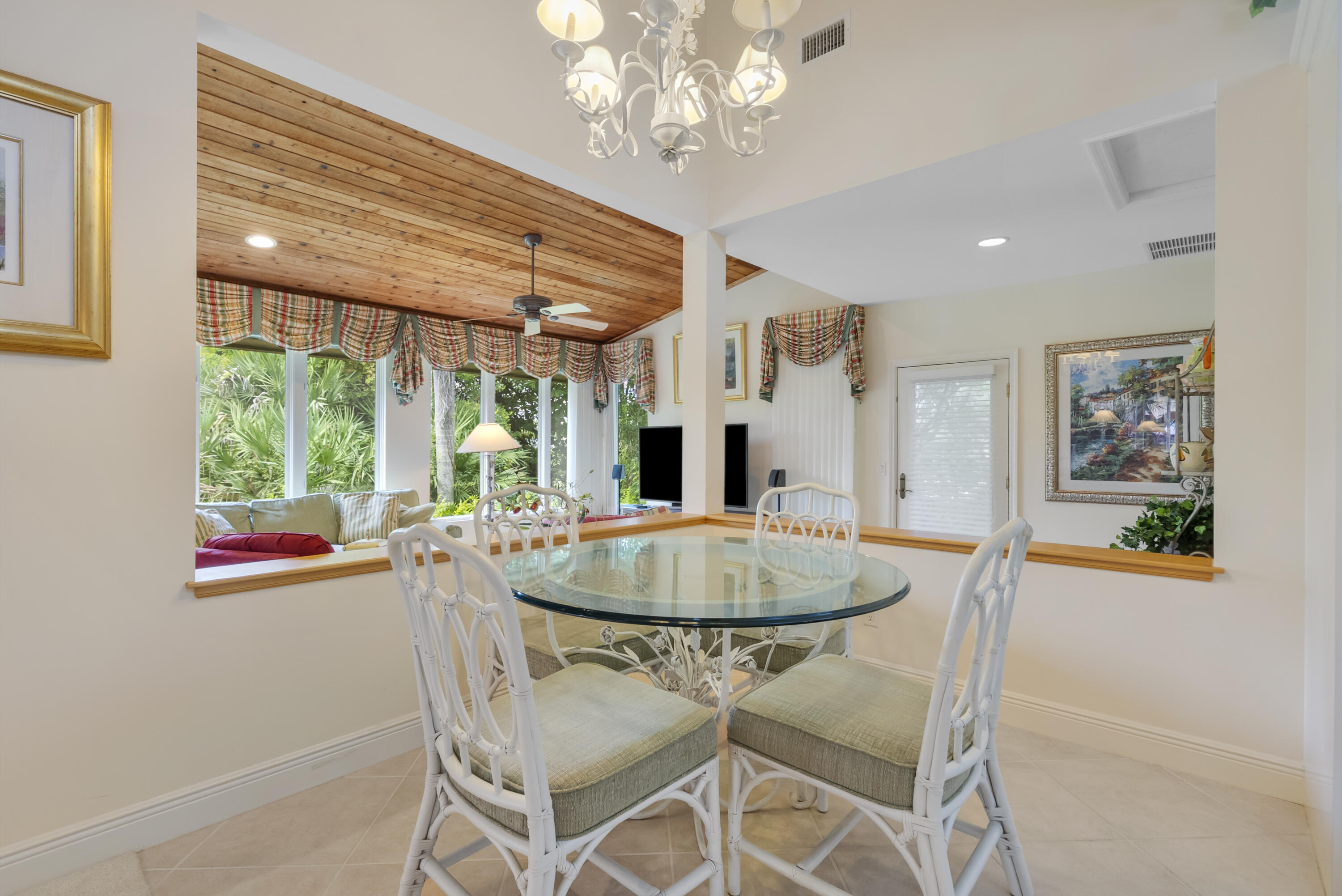 5011 Southeast Burning Tree Circle Stuart, FL 34997 - Photo 17 of 59 a dining room with wooden floor a chandelier a wooden table and chairs