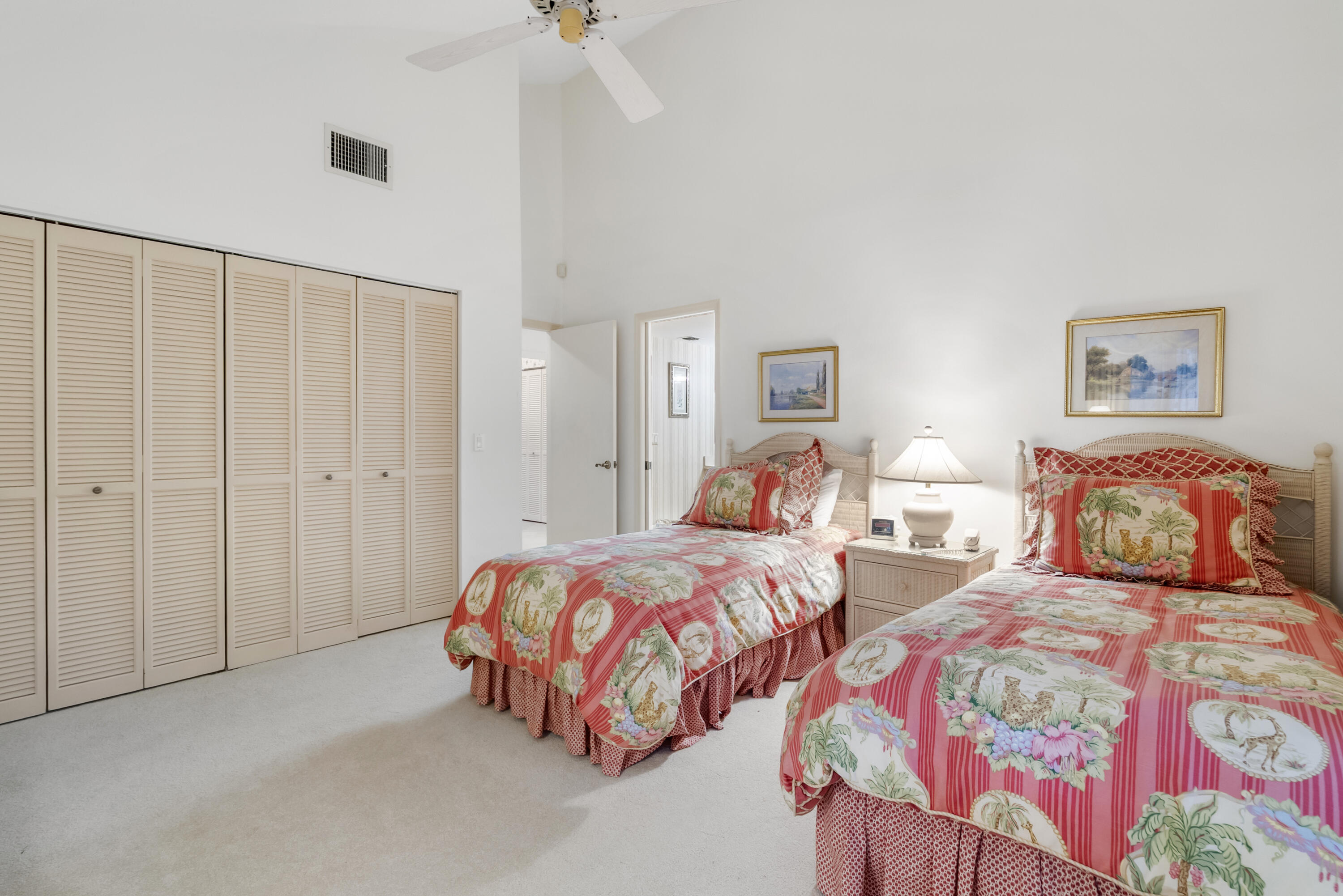 5011 Southeast Burning Tree Circle Stuart, FL 34997 - Photo 31 of 59 a bedroom with two beds and a lamp on the dresser