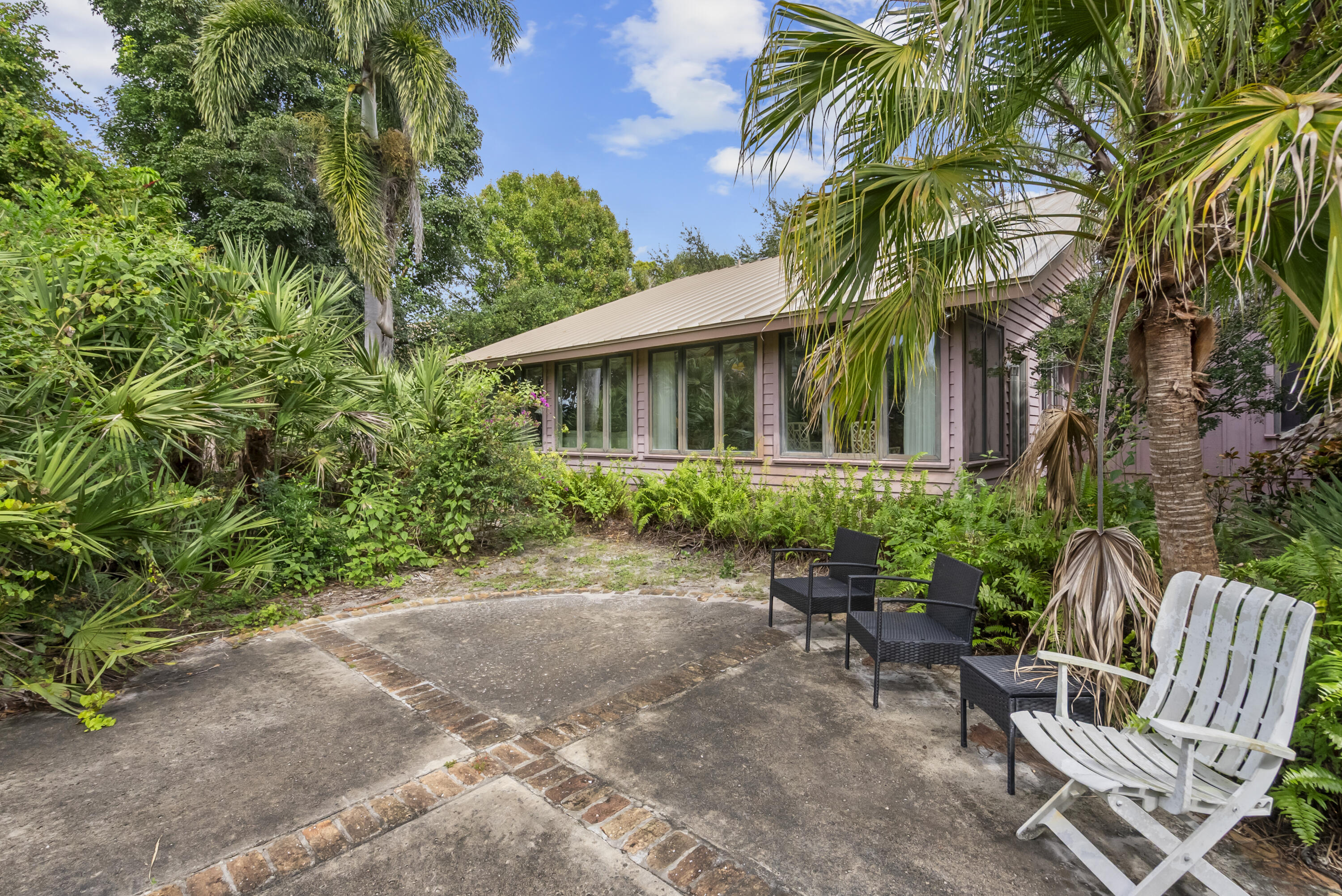 5011 Southeast Burning Tree Circle Stuart, FL 34997 - Photo 39 of 59 a view of backyard with a table and chairs and potted plants