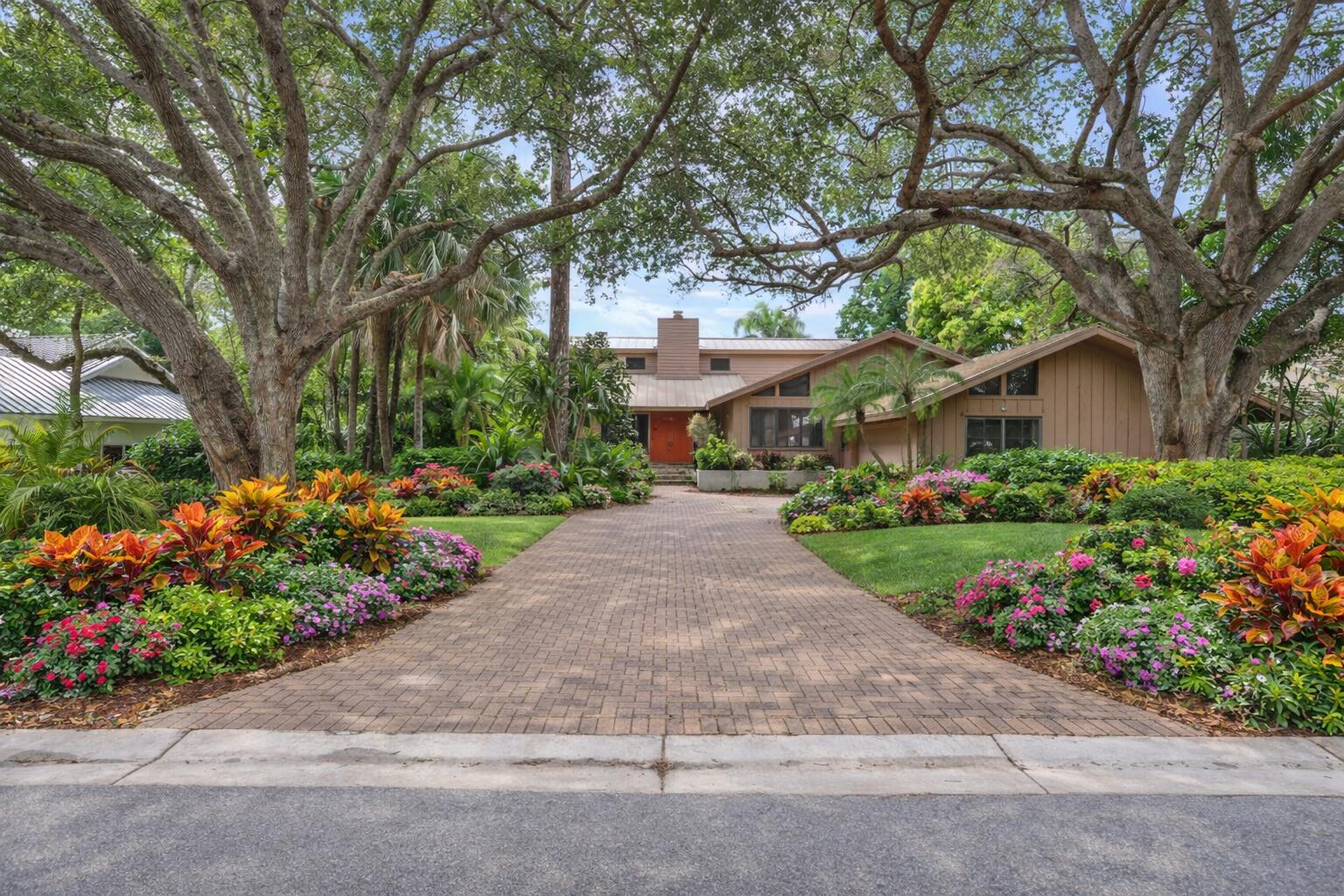 5011 Southeast Burning Tree Circle Stuart, FL 34997 - Photo 4 of 59 a front view of a house with a yard and a garden