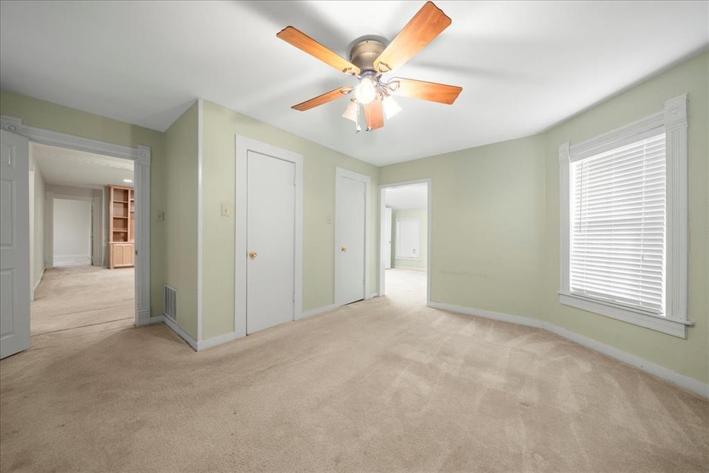 101 North 7th Street Krum, TX 76249 - Photo 12 of 26 Unfurnished bedroom with light colored carpet, ceiling fan, and a closet