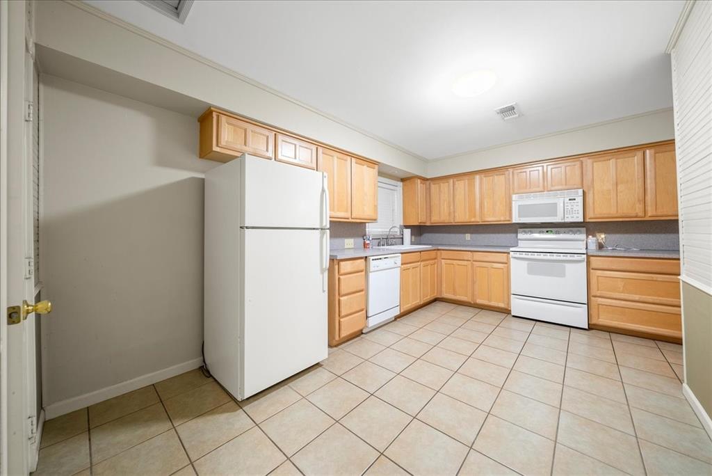101 North 7th Street Krum, TX 76249 - Photo 17 of 26 Kitchen with light brown cabinets, white appliances, light countertops, and light tile patterned flooring