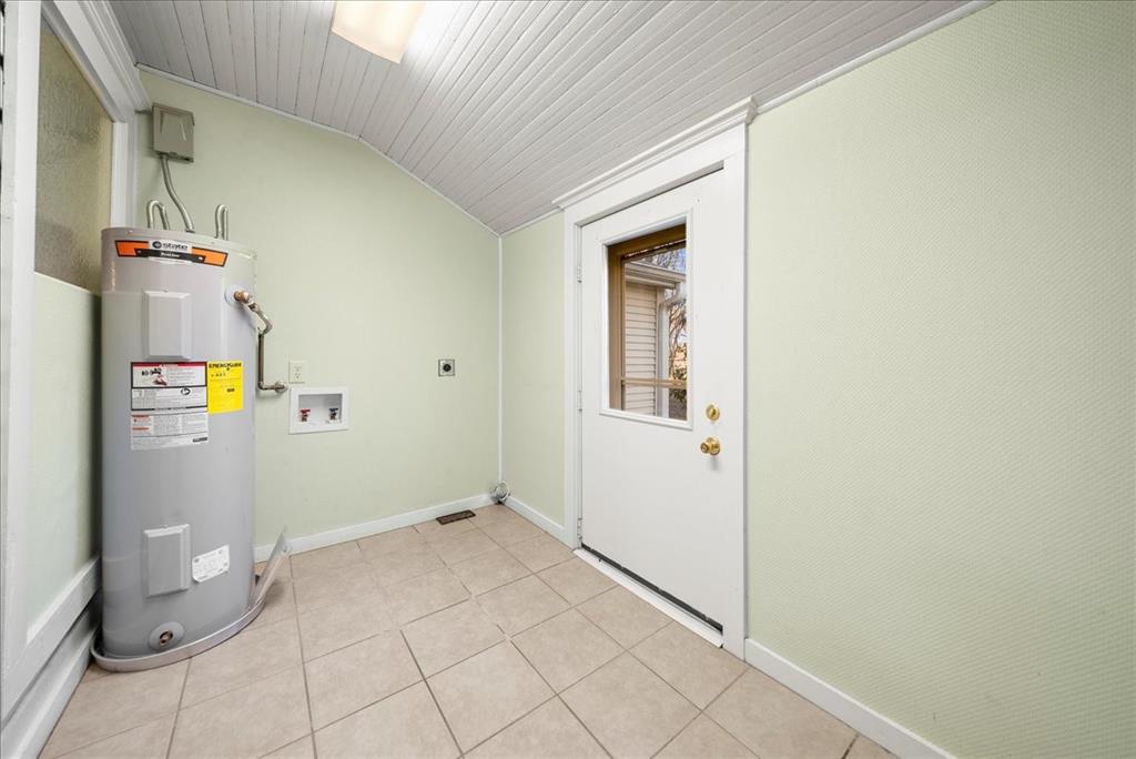 101 North 7th Street Krum, TX 76249 - Photo 19 of 26 Washroom with water heater, lofted ceiling, hookup for an electric dryer, light tile patterned floors, and washer hookup