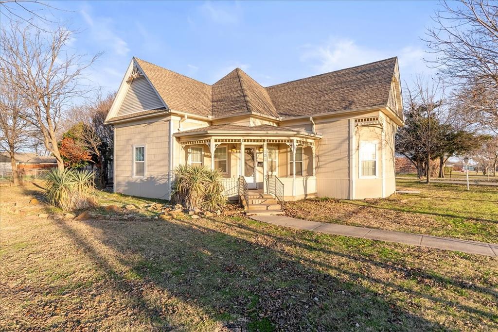 101 North 7th Street Krum, TX 76249 - Photo 2 of 26 Victorian-style house featuring a front lawn, roof with shingles, and covered porch