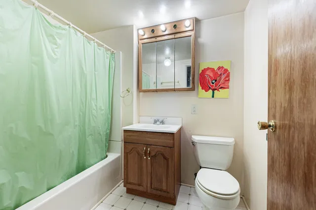 a bathroom with a toilet sink vanity and tub