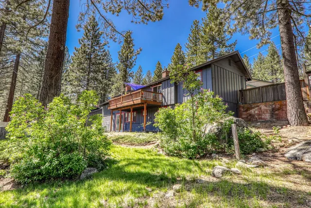 a house is sitting in middle of the forest